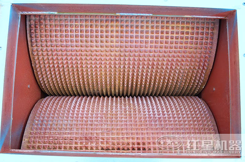 相向轉(zhuǎn)動的兩輥子，調(diào)節(jié)其間隙可改變出料